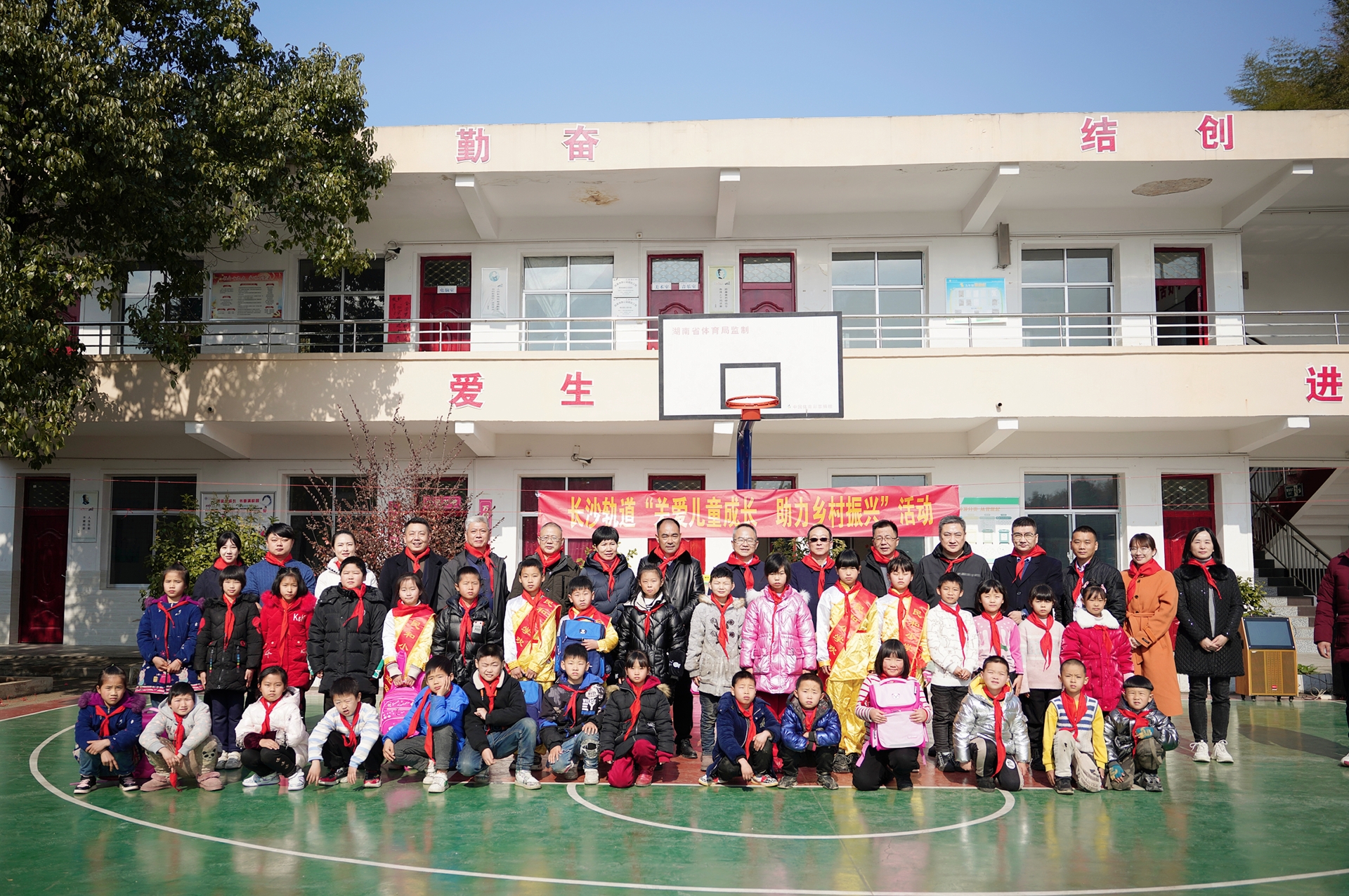 活动成员在活动现场佩戴红领巾与孩子们合影.jpg